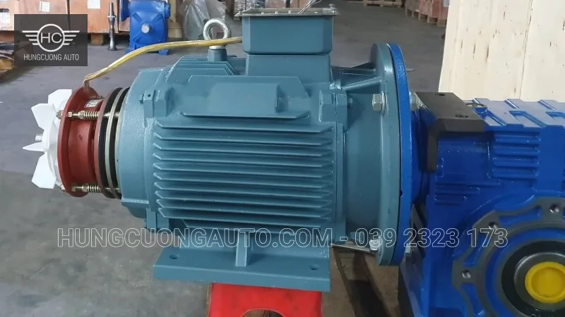 Động cơ có phanh đặt trong kho, nhìn thấy cụm phanh và cánh quạt phía sau.