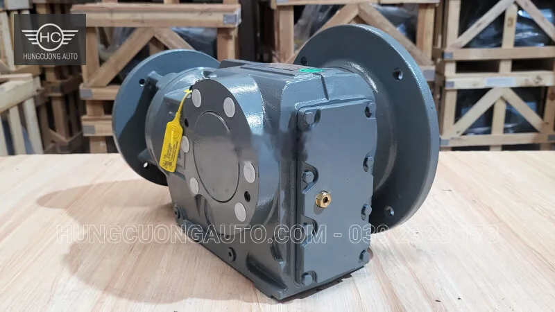 Hộp giảm tốc màu xám nhìn từ phía nắp bên, thấy vòng mặt bích và nút dầu.