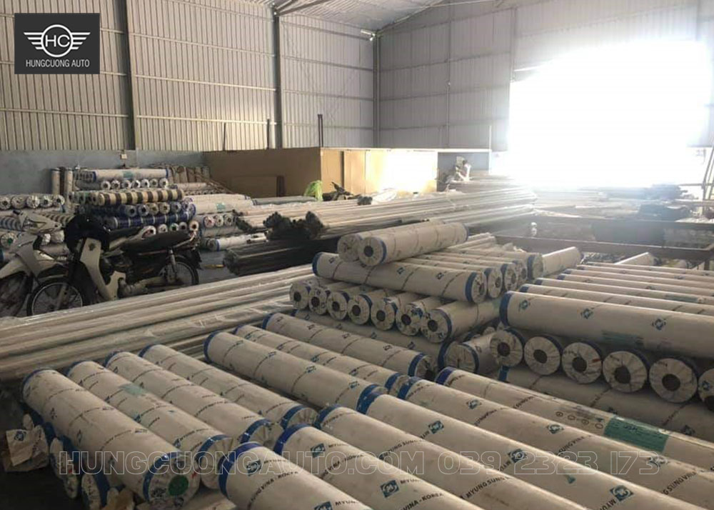 Các cuộn bạt nhiều màu được xếp thành hàng trong kho vật tư