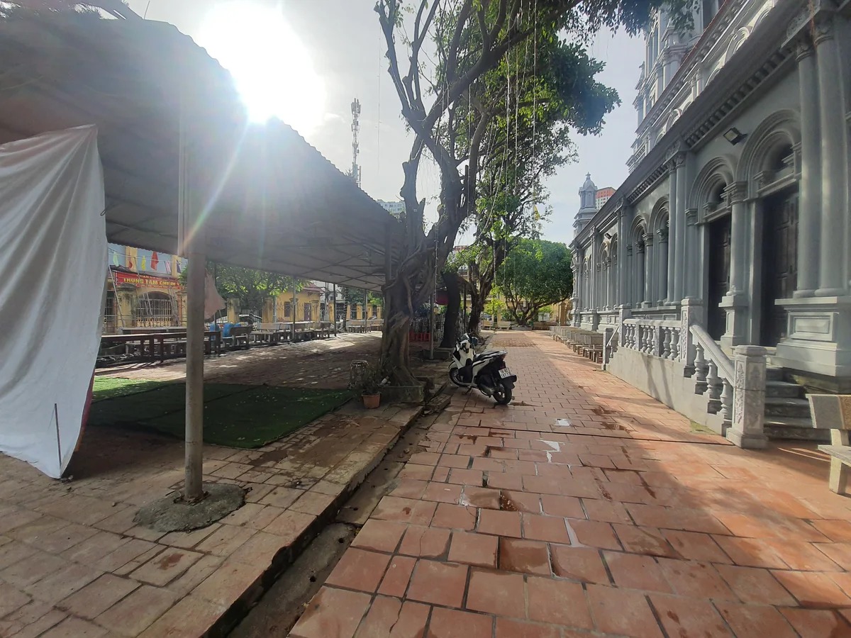 Khoảng sân lát gạch giữa các dãy nhà, có cây lớn và lối đi sát công trình