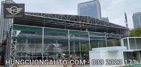 Khung giàn mái lớn đang lắp dựng với các thanh giằng và khu vực rào chắn
