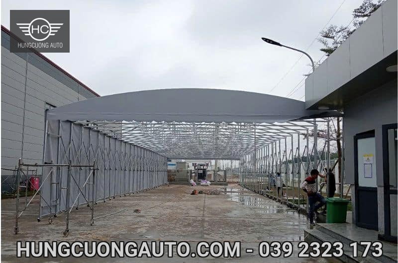 Mái bạt xám đang lắp đặt dọc lối giữa các khối nhà