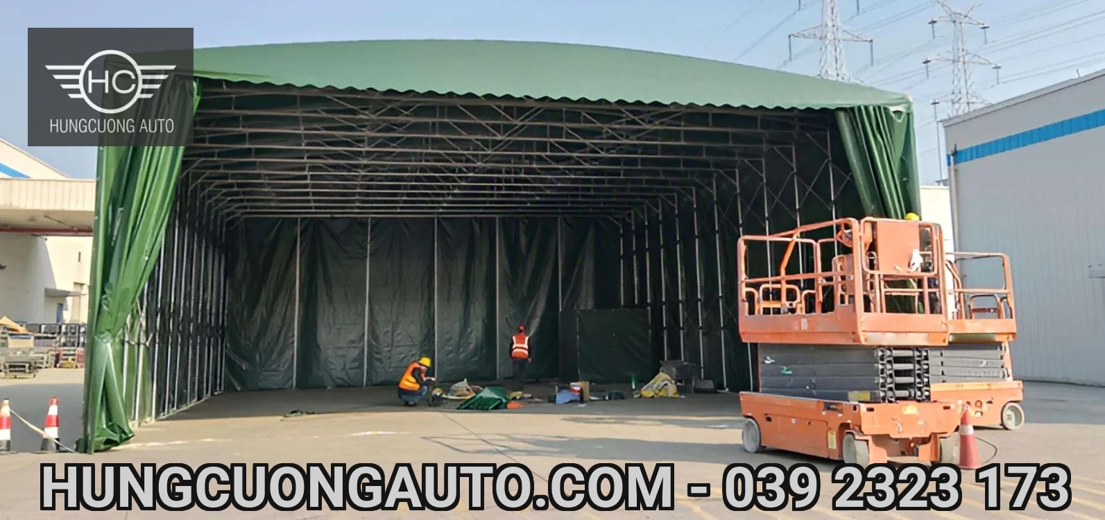 Nhà bạt xanh đang lắp đặt với người thi công và xe nâng người ở phía trước