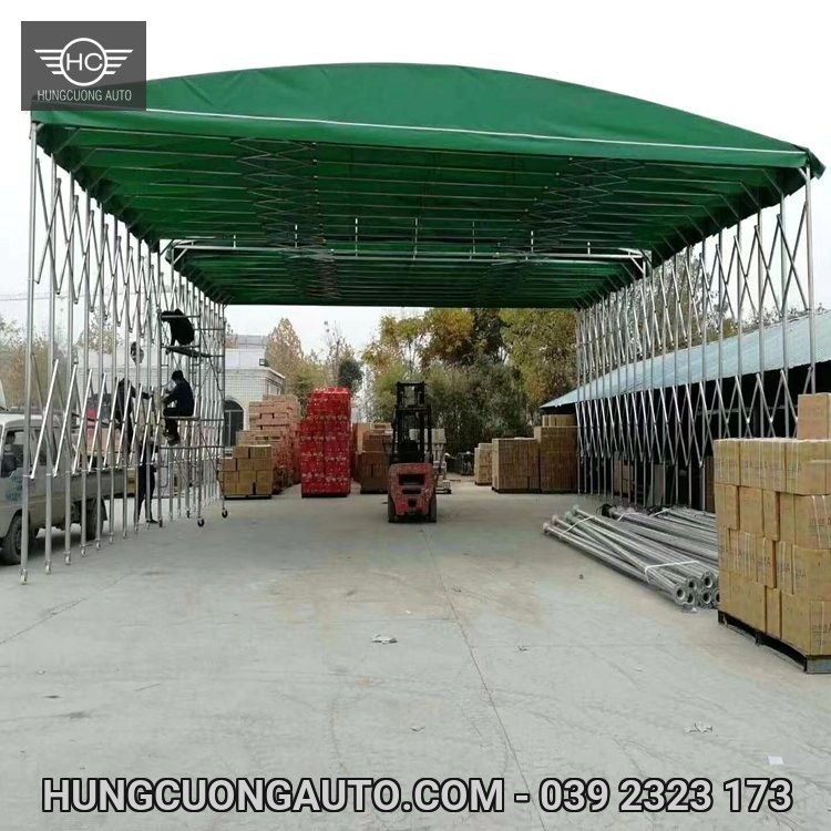 Mái bạt xanh che khu vực tập kết thùng hàng, có xe nâng phía dưới