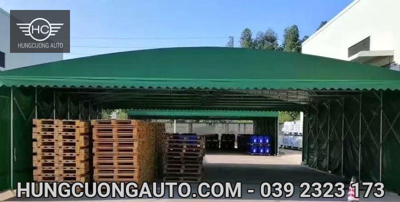 Mái bạt xanh che các chồng pallet gỗ với lối đi ở giữa
