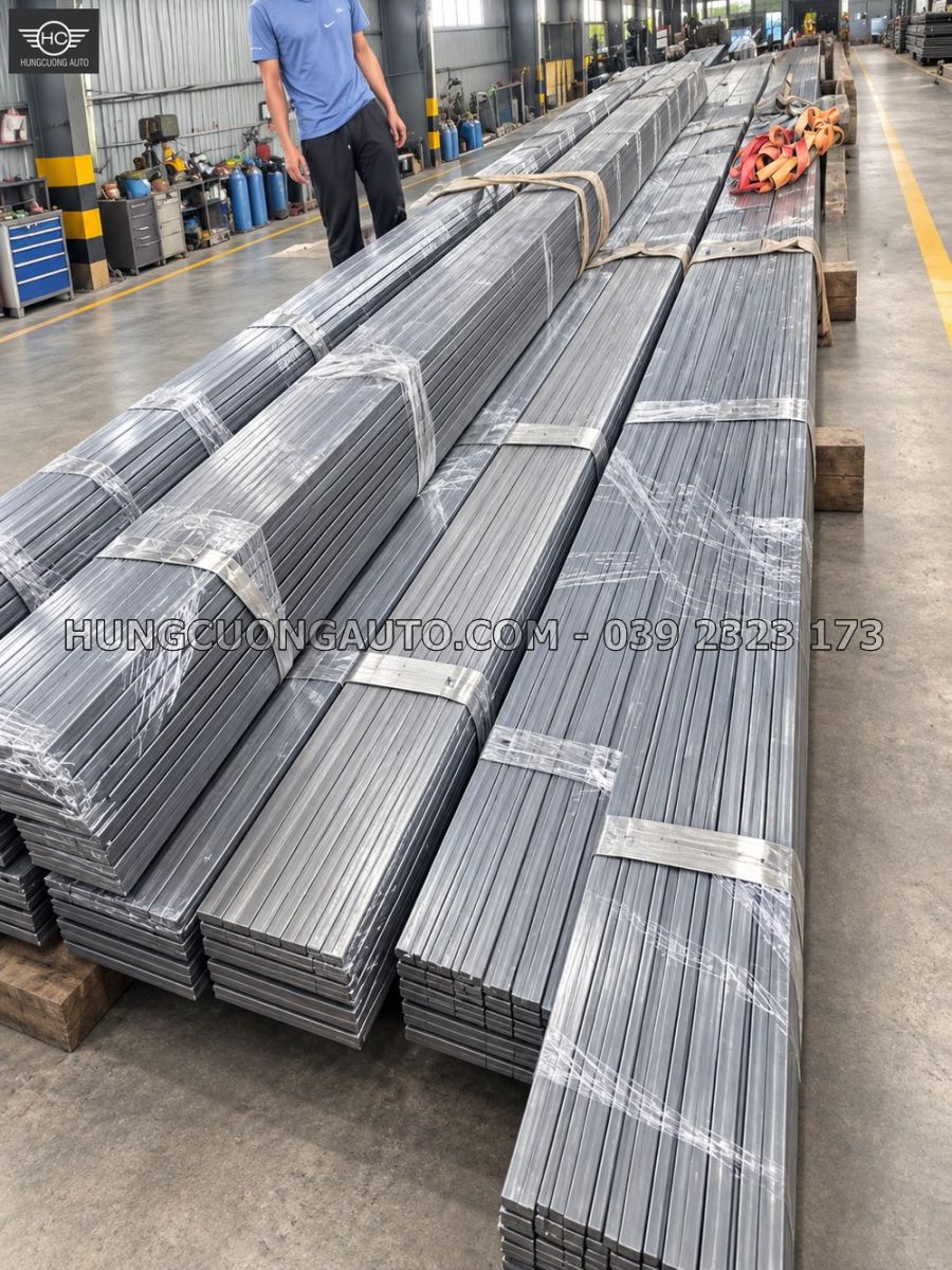 Các thanh ray U dài được bọc và xếp trên nền xưởng